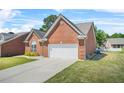Brick home featuring a two-car garage and concrete driveway, surrounded by a green lawn at 8495 Spivey Village Way, Jonesboro, GA 30236