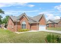 Charming brick home featuring an arched window, two-car garage, and well-maintained lawn at 8495 Spivey Village Way, Jonesboro, GA 30236