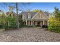 Charming two-story home with a covered front porch and manicured landscaping creates excellent curb appeal at 6050 Providence Ln, Cumming, GA 30040