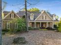 Two-story home with shutters, dormer windows, landscaped yard and covered front porch at 6050 Providence Ln, Cumming, GA 30040