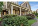 Covered front porch with stately columns, iron work door, and a view of the manicured front lawn at 6050 Providence Ln, Cumming, GA 30040