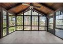 Bright sunroom with tile flooring, wood paneled ceiling, and expansive windows with a view of the trees at 11815 Mountain Laurel Dr, Roswell, GA 30075