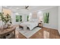 Bright main bedroom featuring hardwood floors, a fireplace, a ceiling fan, and ample natural light at 3988 Dover Ave, Alpharetta, GA 30009