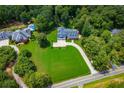 Aerial view of property with expansive lawn and circular driveway, with a neighboring in-ground pool at 4149 Yancey Rd, Douglasville, GA 30135