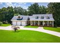 Charming home featuring a spacious front yard, long driveway and inviting front porch with columns at 4149 Yancey Rd, Douglasville, GA 30135