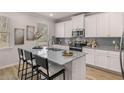 Modern kitchen with stainless steel appliances, granite countertops, tile backsplash, and a large central island at 4532 Ajo Lot#9 Walk, Atlanta, GA 30331