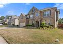 Attractive two-story brick and stone home with a well-kept lawn and colorful flower beds at 4279 Two Bridge Dr, Buford, GA 30518