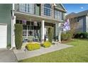 Charming front porch with seating area, decorative plants, and stone accents at 419 Farmwood Way, Canton, GA 30115