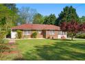Brick home with a red roof and manicured lawn at 566 Huff St, Lawrenceville, GA 30046