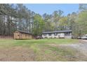 Scenic property featuring a house, shed, and a spacious grassy area at 1302 Brittain Rd, Douglasville, GA 30134