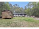 Spacious lot with a house, utility shed, and ample green space at 1302 Brittain Rd, Douglasville, GA 30134