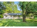 Charming ranch home features a brick exterior, well-manicured lawn, and mature trees, creating a serene setting at 3150 Stonewall Tell Rd, Atlanta, GA 30349