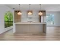 Modern kitchen with stainless steel appliances, large island, and stylish pendant lighting at 644 Glendale Rd, Scottdale, GA 30079