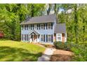 Exterior of beautiful home with black shutters, set on a lush green lot in a neighborhood setting at 1972 Tanglewood Dr, Snellville, GA 30078