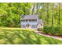 View of the beautiful home with a well-manicured lawn and lush trees surrounding the property at 1972 Tanglewood Dr, Snellville, GA 30078