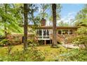 The backyard of this home has a patio, mature trees, and is nicely landscaped with blooming bushes at 2343 Kings Point Dr, Dunwoody, GA 30338