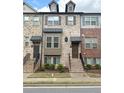 Inviting brick townhome featuring a well-maintained facade and an attractive entryway at 4487 Kerrington Ave, Sugar Hill, GA 30518