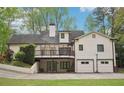 Back of the house featuring a deck on the second story and garage access on ground level at 2972 Nw Stilesboro Nw Rd, Kennesaw, GA 30152