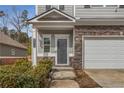 Close up of the home's entryway with stone accents, a covered porch, and manicured landscaping at 9032 Jim Purcell Dr, Covington, GA 30014