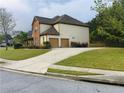 Side view of home with a two-car garage, long driveway, and lush green lawn on a cloudy day at 533 Mount Gerizim Se Rd, Mableton, GA 30126