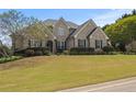 Inviting brick home featuring a manicured front lawn and mature landscaping, enhancing its curb appeal at 5604 Mccullers Ln, Loganville, GA 30052