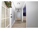 Inviting hallway featuring light blue walls, modern gray flooring, and transom-windowed door at 98 Almon Church Rd, Covington, GA 30014