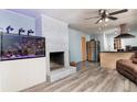 Open-concept living room with a painted fireplace, saltwater aquarium, and modern wood-look flooring at 98 Almon Church Rd, Covington, GA 30014