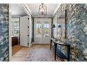 Elegant foyer with patterned wallpaper, light hardwood floors, and a stylish console table at 5255 Heirloom Overlook, Cumming, GA 30040