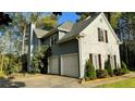 Two-story home with a white brick facade, blue siding, and a two-car garage, set amongst lush trees at 2270 Fenwick Pointe Sw, Marietta, GA 30064