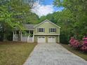 Charming home featuring a front porch, two-car garage, and a well-maintained front yard surrounded by mature trees at 14 Highland Dr, Carrollton, GA 30116