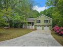 Charming home featuring a front porch, two-car garage, and a well-maintained front yard surrounded by mature trees at 14 Highland Dr, Carrollton, GA 30116