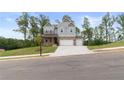 Beautiful two-story home with a manicured lawn, covered porch, and a three-car garage at 7515 Woolf Way, Cumming, GA 30028