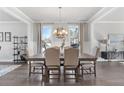 Bright dining room featuring elegant lighting, hardwood floors, and natural light from three windows at 545 Paces Dr, Lithia Springs, GA 30122