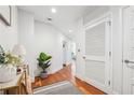 Hallway with hardwood floors, white walls, and storage leading to other areas of the home at 1080 Peachtree Ne St # 2416, Atlanta, GA 30309