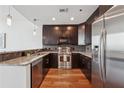 Modern kitchen with stainless steel appliances, granite countertops, and dark wood cabinets at 1080 Peachtree Ne St # 2416, Atlanta, GA 30309