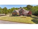 Brick home with a lush lawn, landscaped garden beds, and circular walkway at 222 Rippling Nw Dr, Marietta, GA 30064