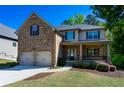 Charming two-story brick home with a two-car garage and a cozy covered porch at 3228 Trinity Mill Cir, Dacula, GA 30019