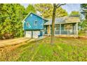 Charming home featuring a two-car garage and covered porch, surrounded by mature trees at 622 Jockey Ln, Auburn, GA 30011