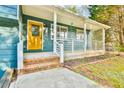 Cozy front porch with white railings and a bright yellow front door, inviting and charming at 622 Jockey Ln, Auburn, GA 30011