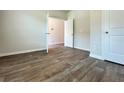 Cozy bedroom showcasing neutral walls, wood-look flooring, and ample natural light streaming through an open doorway at 679 Egrets Landing Lot 57, Covington, GA 30014