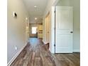 Inviting hallway features stylish wood flooring and neutral wall paint, leading to a bright and modern kitchen at 679 Egrets Landing Lot 57, Covington, GA 30014