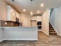Modern kitchen with stainless steel appliances, granite countertops, and a convenient breakfast bar adjacent to carpeted stairs at 679 Egrets Landing Lot 57, Covington, GA 30014