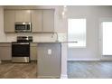 Modern kitchen featuring stainless steel appliances, sleek cabinets, and wood-look flooring at 679 Egrets Landing Lot 57, Covington, GA 30014