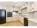 Functional kitchen with wood cabinets, black appliances, and a durable patterned floor at 1316 Sanders Dr, Morrow, GA 30260
