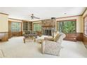 Spacious living room with a stone fireplace, built-in shelves, and large windows overlooking the backyard at 1316 Sanders Dr, Morrow, GA 30260