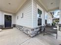 Welcoming front porch with a wreath on the door, a seating area, and stone accents on the pillars at 5515 Allegre Pl, Cumming, GA 30028