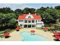 Luxury home with a red roof, balcony, resort-style pool, and red umbrellas at 685 Egrets Lot 58 Lndg, Covington, GA 30014