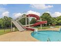 Community pool featuring a thrilling waterslide, lush landscaping, and a serene recreational space at 685 Egrets Lot 58 Lndg, Covington, GA 30014