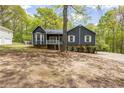Well-maintained home with blue siding, white trim, a cozy front porch and mature trees in a quiet, landscaped setting at 2724 Bomar Rd, Douglasville, GA 30135