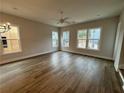 Open-concept living room with wood floors and lots of natural light from large windows at 455 Firefly Cir # 39, Alpharetta, GA 30009